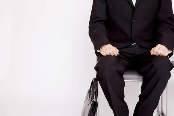 Junger Geschäftsmann Sitzt Auf Stuhl Vor Isoliertem Hintergrund — Stockfoto