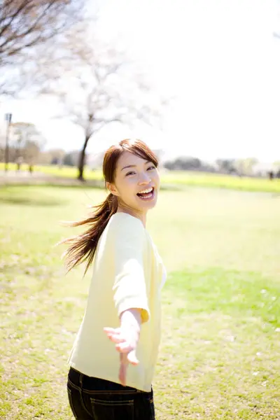 一位年轻迷人的亚洲女子在公园里冲着相机跑着微笑 — 图库照片