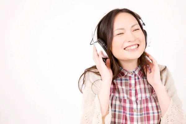 白い背景に隔離されたヘッドホンで音楽を聞く美しい幸せな若い女性の肖像画 — ストック写真