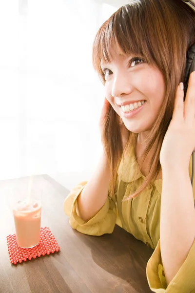 ヘッドフォンとドリンクの日本人女性 — ストック写真