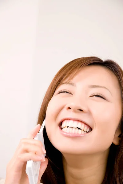 Портрет Счастливой Японки Использующей Мобильный Телефон Дома Стоковое Фото