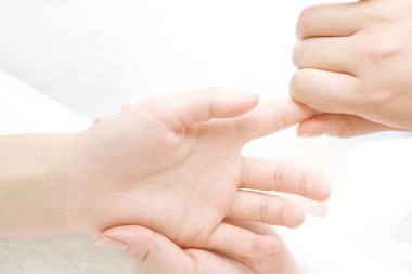 Genç bir kadın kuaförde el masajı yaptırıyor.