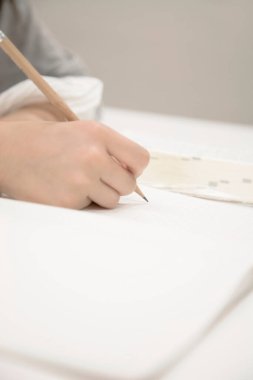 Kalem kullanarak ders çalışan liseli kız.