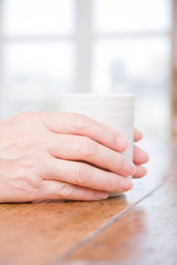 Çay fincanı taşıyan Asyalı son sınıf öğrencisi. 