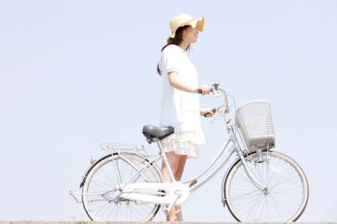 Parkta bisikleti olan genç bir kadın. 