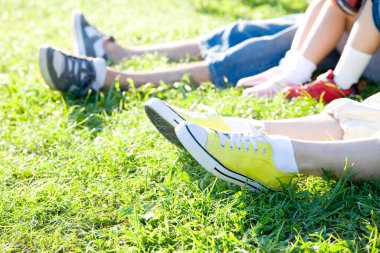 Ailenin bacakları parkta yan yana oturuyor, rahatlıyor.