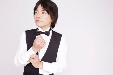 Genç Asyalı garson izole edilmiş arka planda üniforma giyiyor.  