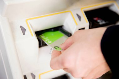 Asyalı genç adam metroda bilet alıyor. 