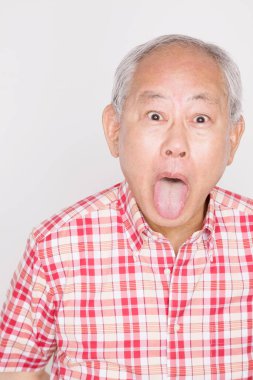 Asyalı kıdemli adam dil uzatıyor.