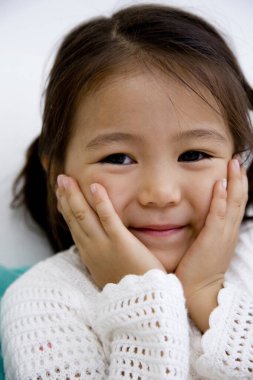 Yüzünde elleri olan küçük bir kız.