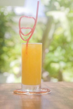 Bir bardak portakal suyu ve açık havada pipet içmek.
