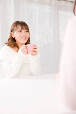 Genç bayan evde kahve içiyor.