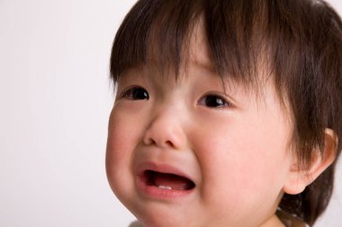 Küçük tatlı Asyalı kız portresi ağlıyor, izole edilmiş.