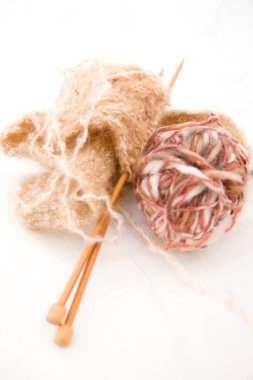 Hafif bir arka planda örgü iğneleri ve iplikler.