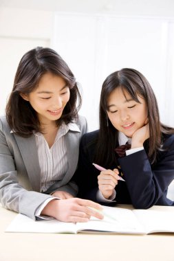 Güzel Japon bayan öğretmenin portresi okul için yeni materyalleri açıklıyor.   