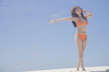 Genç Japon kadın sahilde bikinili poz veriyor.