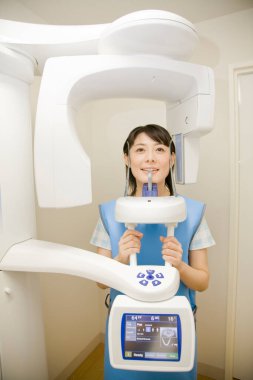 Genç Asyalı kadın dişlerinin röntgenini çekiyor.