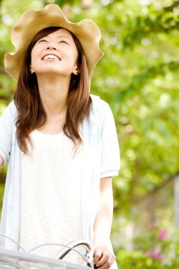 Asyalı kadın parkta dinleniyor, yaz günü.