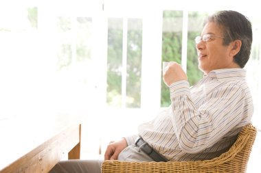 Yakışıklı, emekli bir Japon 'un sabah kahvesini yudumlarken çekilmiş portresi.