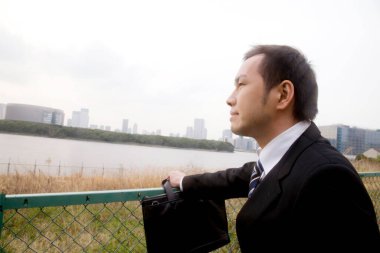 Takım elbiseli ve şapkalı adam ufka bakıyor.