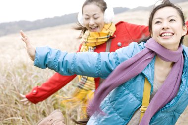 İki mutlu Asyalı kadın kırsal alanda eğleniyor.