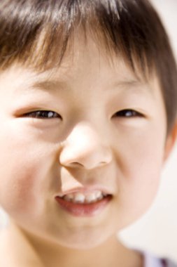 Yakışıklı gülümseyen Asyalı çocuğun portresini yakından çek.
