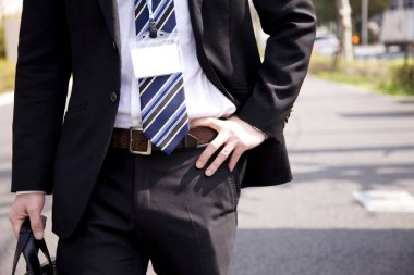 İşadamı rozetle ofise giriyor. 