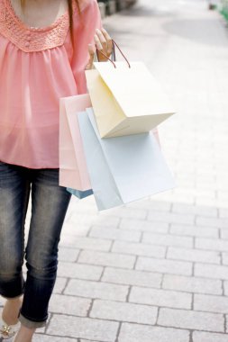 Renkli kağıt torbaları tutan kadın.