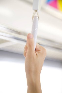 Metro treninde tırabzanı tutan bir kadın eli. 