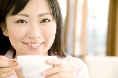 Kafede çay içen genç Asyalı kadın.