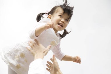 Babam onu fırlatırken Asyalı küçük kız gülüyor.