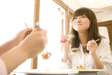 Kafede yemek yiyen genç Japon kadınları.