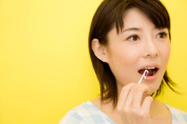 Diş ipi kullanan Asyalı genç bir kadın. 