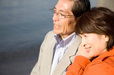 Mutlu Asyalı olgun bir çiftin açık havada çekilmiş portresi.