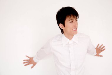 Yakışıklı Asyalı adam günlük beyaz gömlek giyiyor.