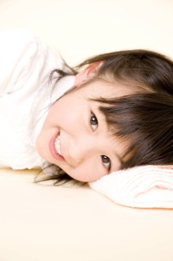 Yatakta yatan Asyalı küçük kızın portresi. 