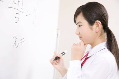 Japon liseli kız, parlak ve modern bir sınıftaki derslerine odaklandı.