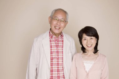 Kameraya bakan yaşlı Japon çiftin portresi.