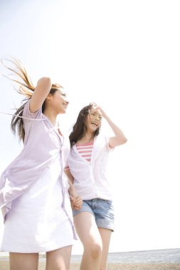 Mutlu Asyalı kızlar sahilde eğleniyor. 