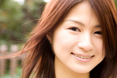 Güzel, mutlu, Asyalı bir kadının açık havada portresi.