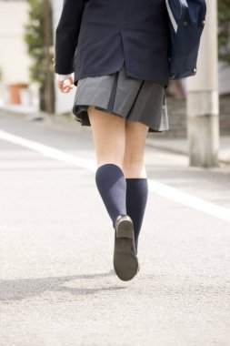 Sokakta koşan üniformalı güzel Japon kız.