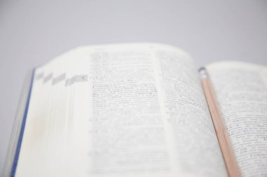 Gri arkaplanda kurşun kalemle açılan kitap