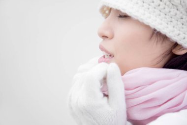 Sıcak beyaz eldiven ve şapka giyen Asyalı bir kadın.