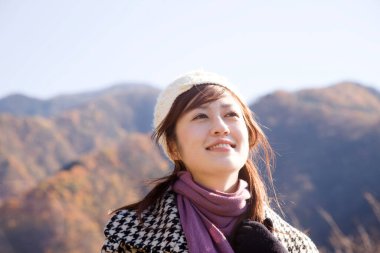 Genç Asyalı kadın dağlarda yürüyor. 