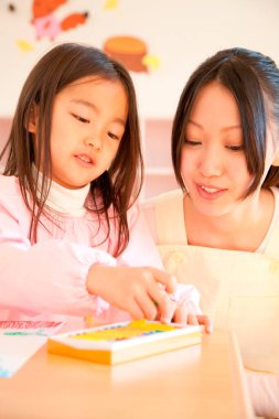 Annesiyle resim çizen tatlı Asyalı küçük kız.