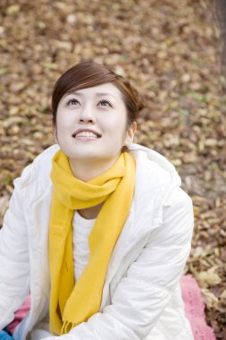 Sonbahar parkında poz veren genç Japon kadının portresi.