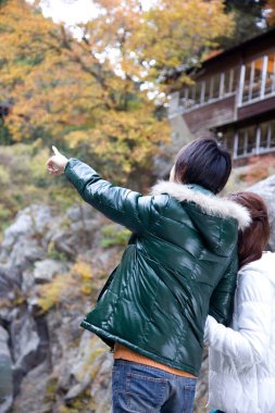 Genç Japon çift sonbahar ormanında eğleniyor. 
