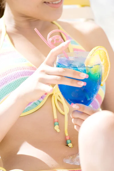 Pretty Japanese woman in swimsuit resting on beach at daytime, summer vacation concept