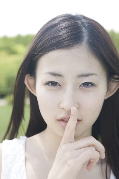 Piękna Młoda Japonka Gestykulująca Ciszą Patrząca Kamerę Zewnątrz — Zdjęcie stockowe