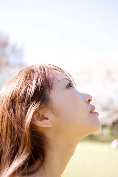 吸引人的年轻亚洲女子俯瞰公园的侧视图 — 图库照片